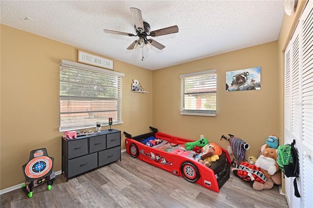 3417 49th St W, Bradenton, FL 34209 - bedroom with wood finished floors, a textured ceiling, a ceiling fan, a closet, and baseboards