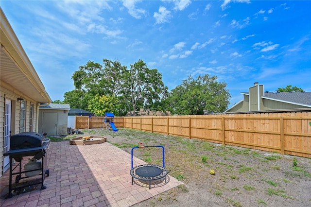 3417 49th St W, Bradenton, FL 34209 - fenced backyard with a fire pit, a patio area, a playground, and a grill