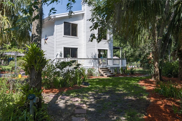 7251 Fish Farm Rd, Palmetto, FL 34221 - rear view of property with a wooden deck, a chimney, and a yard