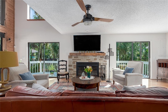 7251 Fish Farm Rd, Palmetto, FL 34221 - living area featuring a ceiling fan, a textured ceiling, a stone fireplace, wood finished floors, and a high ceiling
