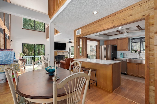 7251 Fish Farm Rd, Palmetto, FL 34221 - dining area with a ceiling fan, a fireplace, light wood-style floors, and a textured ceiling