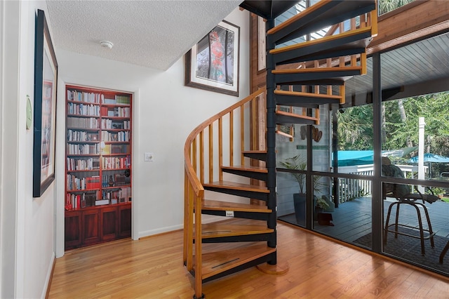7251 Fish Farm Rd, Palmetto, FL 34221 - staircase featuring wood finished floors, a textured ceiling, and baseboards