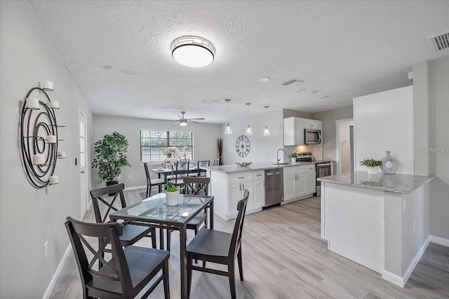 400 E Baffin Dr, Venice, FL 34293 - dining space with light wood finished floors, a textured ceiling, and a ceiling fan