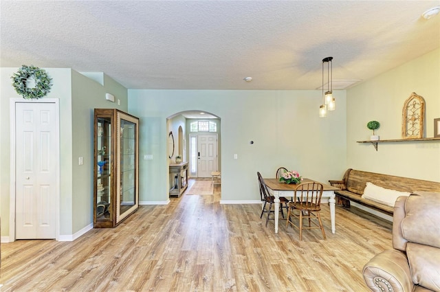 11254 82nd St E, Parrish, FL 34219 - dining space with arched walkways, wood finished floors, a textured ceiling, and baseboards