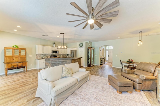 11254 82nd St E, Parrish, FL 34219 - living area with arched walkways, light wood-style floors, a ceiling fan, baseboards, and recessed lighting