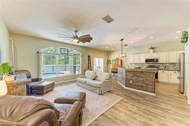 11254 82nd St E, Parrish, FL 34219 - living area featuring a textured ceiling, light wood-style flooring, recessed lighting, a ceiling fan, and baseboards