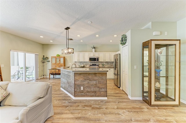 11254 82nd St E, Parrish, FL 34219 - kitchen with stainless steel appliances, open floor plan, light wood-type flooring, white cabinets, and recessed lighting