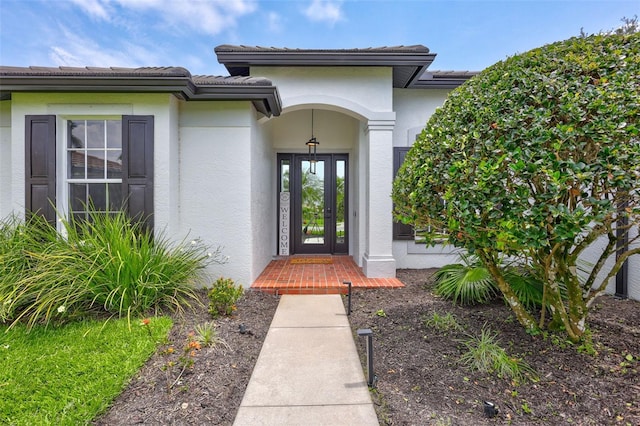 5285 Far Oak Cir, Sarasota, FL 34238 - view of exterior entry featuring french doors, stucco siding, and a tile roof