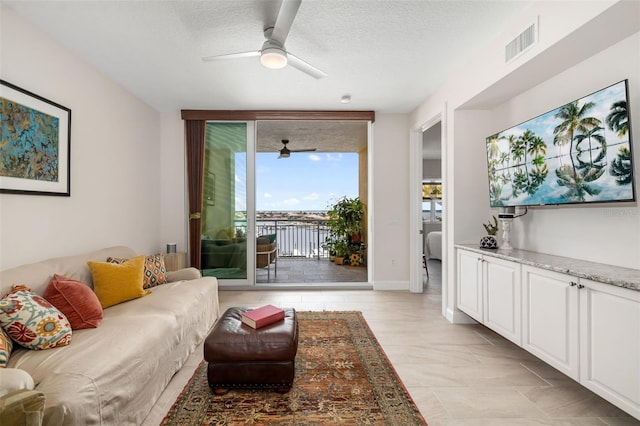 610 Riviera Dunes Way Unit 503, Palmetto, FL 34221 - living area featuring a ceiling fan and a textured ceiling