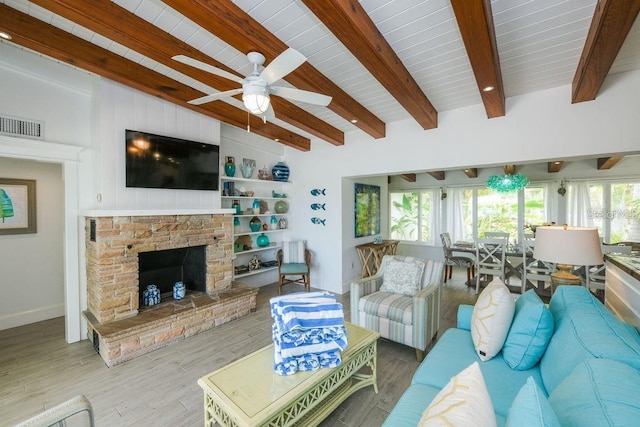 102 77th St, Holmes Beach, FL 34217 - living room featuring ceiling fan, wood finished floors, baseboards, a stone fireplace, and wooden ceiling with exposed beams
