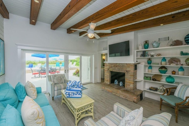 102 77th St, Holmes Beach, FL 34217 - living area with a brick fireplace, a ceiling fan, wood finished floors, and wooden ceiling with exposed beams