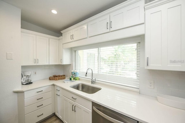 102 77th St, Holmes Beach, FL 34217 - kitchen with a sink, stainless steel dishwasher, decorative backsplash, light countertops, and white cabinetry