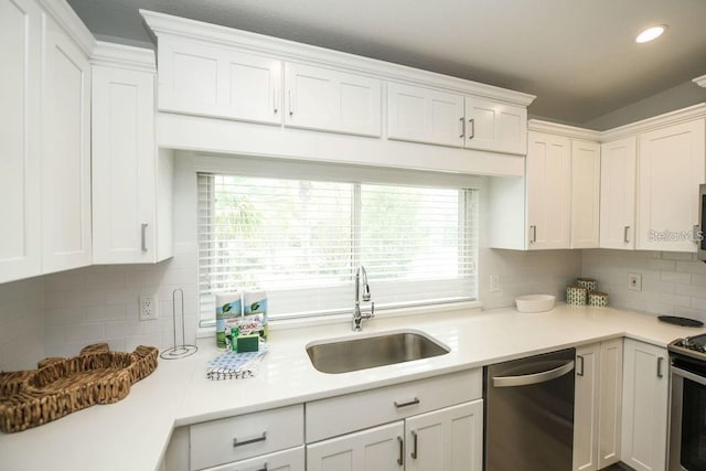 102 77th St, Holmes Beach, FL 34217 - kitchen featuring appliances with stainless steel finishes, a sink, light countertops, backsplash, and white cabinetry