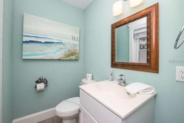 102 77th St, Holmes Beach, FL 34217 - bathroom featuring vanity, toilet, baseboards, and wood finished floors