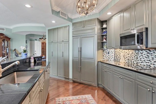 401 N Point Rd Unit 504, Osprey, FL 34229 - kitchen featuring a chandelier, stainless steel microwave, a sink, crown molding, and paneled refrigerator