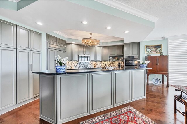 401 N Point Rd Unit 504, Osprey, FL 34229 - kitchen with gray cabinetry, stainless steel microwave, dark countertops, ornamental molding, and recessed lighting