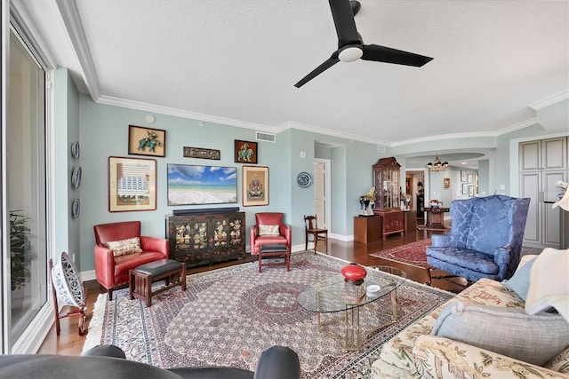 401 N Point Rd Unit 504, Osprey, FL 34229 - living area featuring wood finished floors, crown molding, arched walkways, a ceiling fan, and a textured ceiling