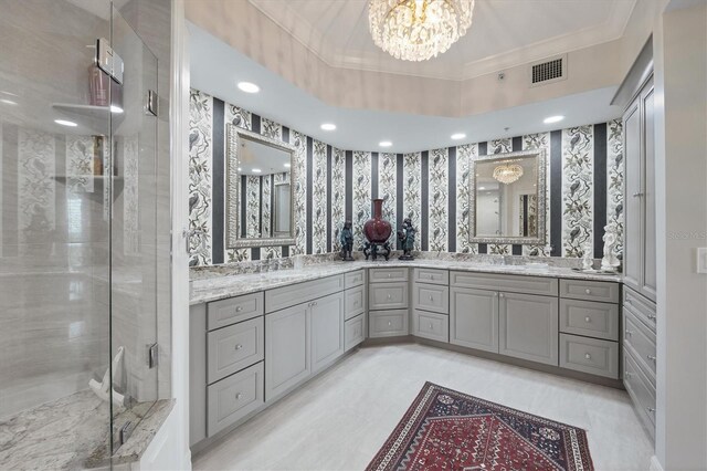 401 N Point Rd Unit 504, Osprey, FL 34229 - bathroom featuring a chandelier, double vanity, a shower stall, ornamental molding, and wallpapered walls