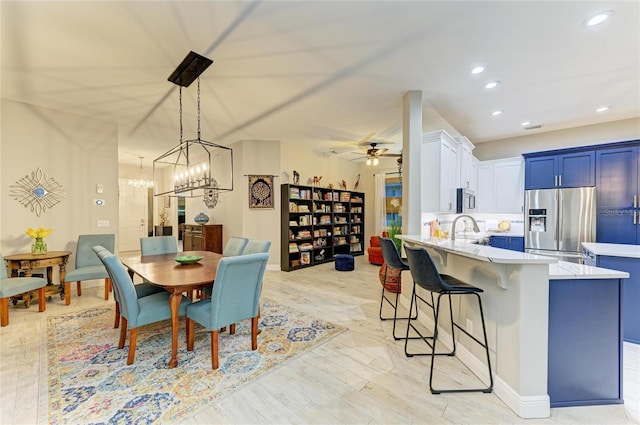 12175 Maple Ridge Dr, Parrish, FL 34219 - dining area with a ceiling fan, light wood finished floors, recessed lighting, and a chandelier