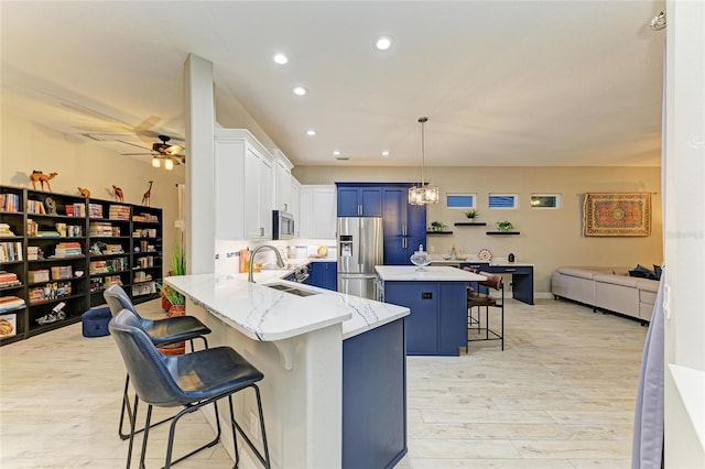 12175 Maple Ridge Dr, Parrish, FL 34219 - kitchen featuring appliances with stainless steel finishes, a breakfast bar, light stone countertops, open floor plan, and recessed lighting