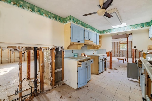 1921 Fairview Dr, Englewood, FL 34223 - kitchen with blue cabinetry, light countertops, a ceiling fan, and decorative backsplash