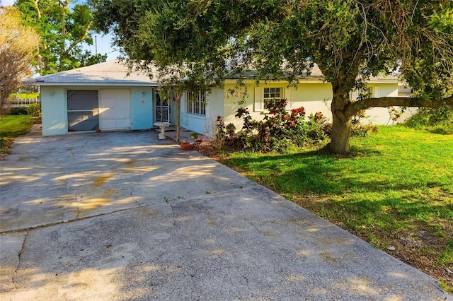 1921 Fairview Dr, Englewood, FL 34223 - view of front of house featuring driveway, stucco siding, a front lawn, and a garage