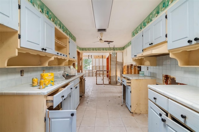 1921 Fairview Dr, Englewood, FL 34223 - kitchen featuring tile countertops, decorative backsplash, open shelves, and ceiling fan