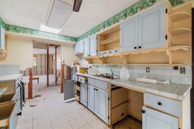1921 Fairview Dr, Englewood, FL 34223 - kitchen with open shelves, decorative backsplash, a sink, and tile counters