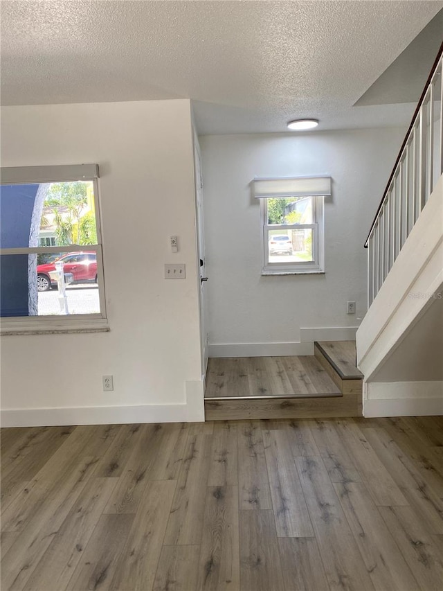 1947 Los Lomas Dr, Clearwater, FL 33763 - entryway featuring a textured ceiling, plenty of natural light, wood finished floors, baseboards, and stairway
