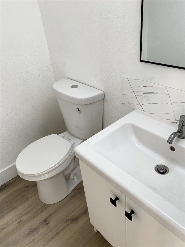 1947 Los Lomas Dr, Clearwater, FL 33763 - half bath featuring wood finished floors, vanity, toilet, and a textured wall