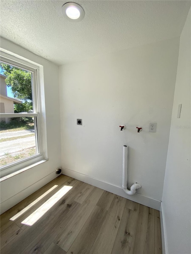 1947 Los Lomas Dr, Clearwater, FL 33763 - washroom with wood finished floors, a textured ceiling, baseboards, and electric dryer hookup