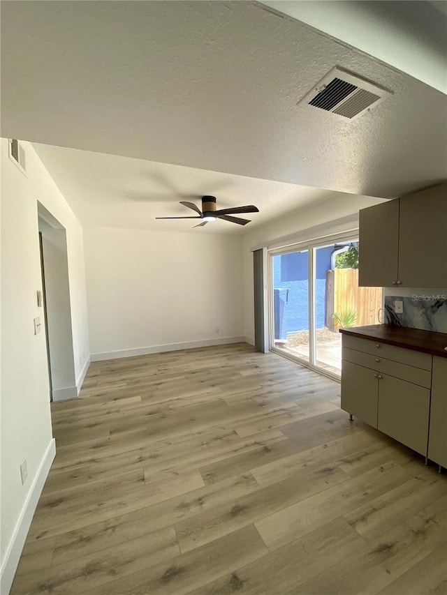 1947 Los Lomas Dr, Clearwater, FL 33763 - interior space featuring light wood finished floors, baseboards, ceiling fan, and a textured ceiling