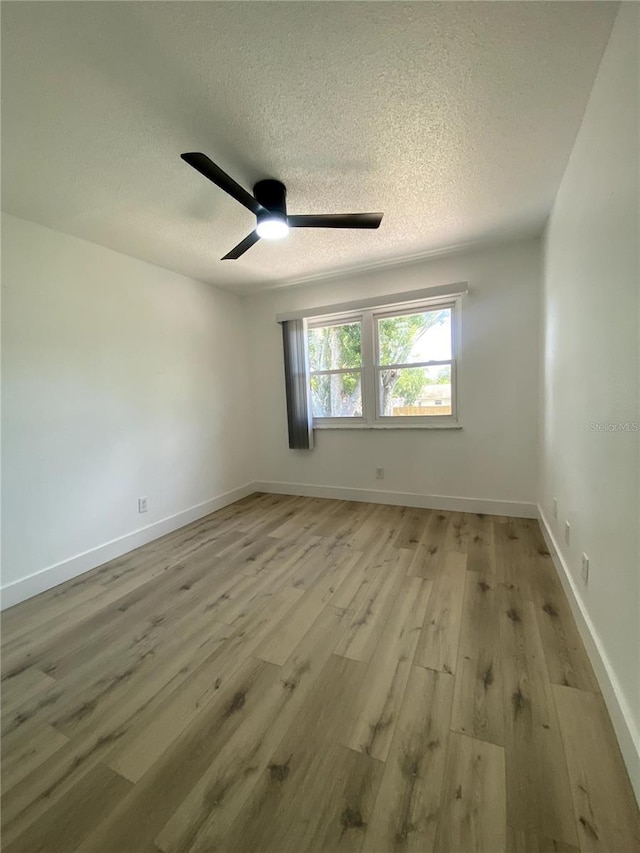 1947 Los Lomas Dr, Clearwater, FL 33763 - unfurnished room with light wood-type flooring, ceiling fan, a textured ceiling, and baseboards