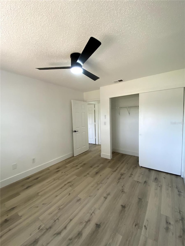 1947 Los Lomas Dr, Clearwater, FL 33763 - unfurnished bedroom featuring a textured ceiling, wood finished floors, baseboards, and a closet