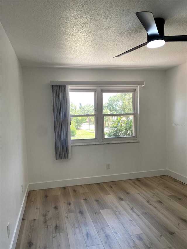 1947 Los Lomas Dr, Clearwater, FL 33763 - empty room with a textured ceiling, wood finished floors, baseboards, and a ceiling fan