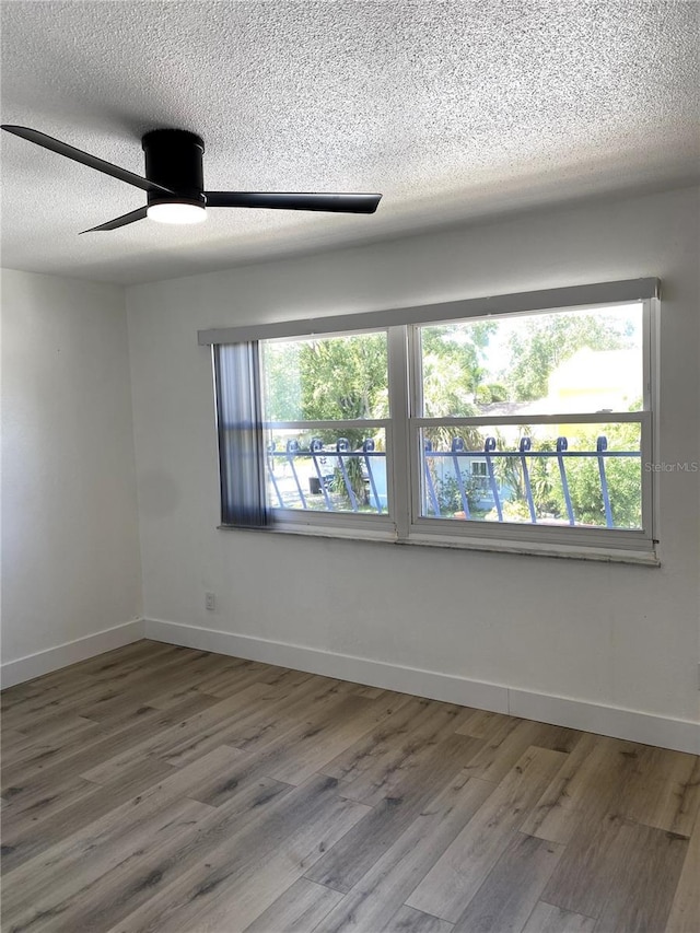 1947 Los Lomas Dr, Clearwater, FL 33763 - spare room with a textured ceiling, wood finished floors, a ceiling fan, and baseboards
