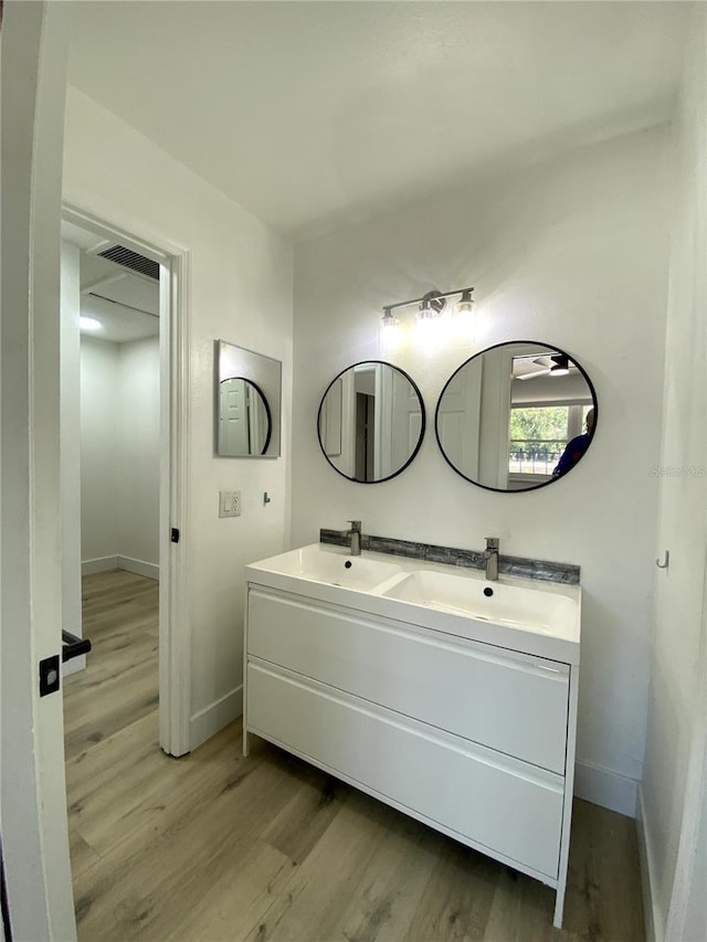 1947 Los Lomas Dr, Clearwater, FL 33763 - full bathroom with wood finished floors, double vanity, and baseboards