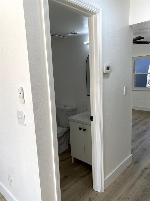 1947 Los Lomas Dr, Clearwater, FL 33763 - bathroom with wood finished floors, vanity, baseboards, and toilet