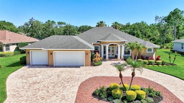 15006 21st Ave E, Bradenton, FL 34212 - view of front of house with french doors, a front lawn, an attached garage, and stucco siding