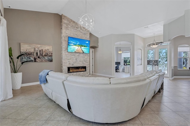 15006 21st Ave E, Bradenton, FL 34212 - living room with light tile patterned floors, a chandelier, a fireplace, baseboards, and high vaulted ceiling