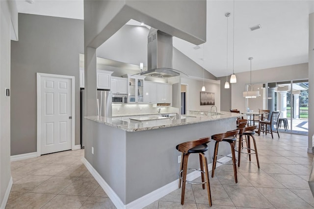 15006 21st Ave E, Bradenton, FL 34212 - kitchen featuring high vaulted ceiling, wall chimney exhaust hood, stainless steel microwave, white cabinets, and glass insert cabinets