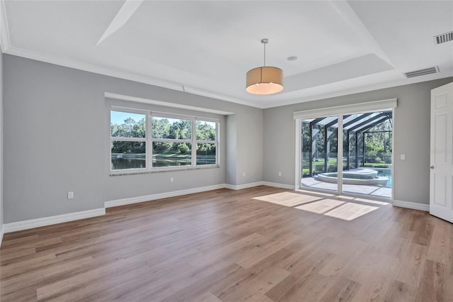 15006 21st Ave E, Bradenton, FL 34212 - unfurnished room featuring plenty of natural light, baseboards, light wood-style flooring, a tray ceiling, and crown molding