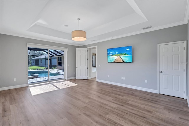 15006 21st Ave E, Bradenton, FL 34212 - spare room with a raised ceiling, baseboards, wood finished floors, and crown molding