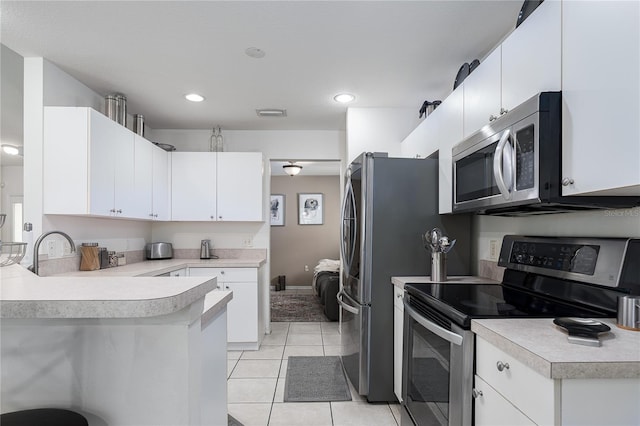 4811 69th Ct E, Palmetto, FL 34221 - kitchen with appliances with stainless steel finishes, light countertops, light tile patterned floors, a peninsula, and recessed lighting