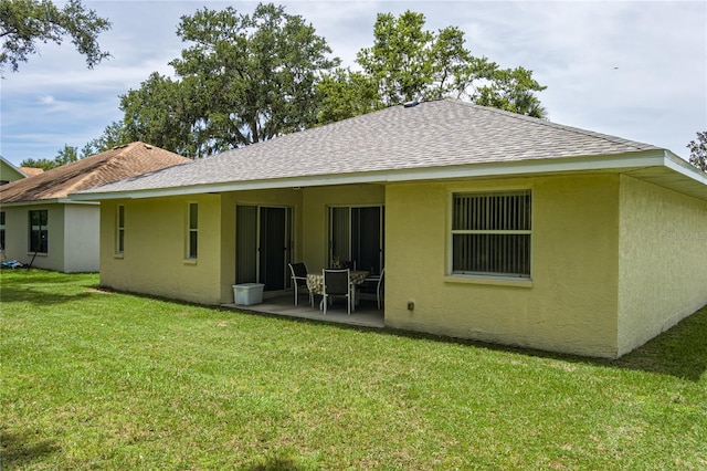 4811 69th Ct E, Palmetto, FL 34221 - back of property with stucco siding, a shingled roof, a patio, and a lawn