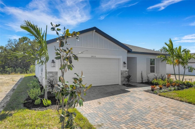 5213 Patano Loop, Palmetto, FL 34221 - view of front facade featuring a garage, board and batten siding, decorative driveway, stone siding, and stucco siding