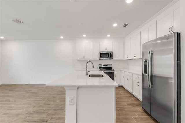 5213 Patano Loop, Palmetto, FL 34221 - kitchen with appliances with stainless steel finishes, a sink, wood tiled floors, recessed lighting, and white cabinetry