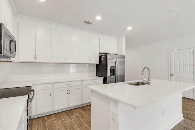 5213 Patano Loop, Palmetto, FL 34221 - kitchen with appliances with stainless steel finishes, a sink, wood tiled floors, backsplash, and white cabinets