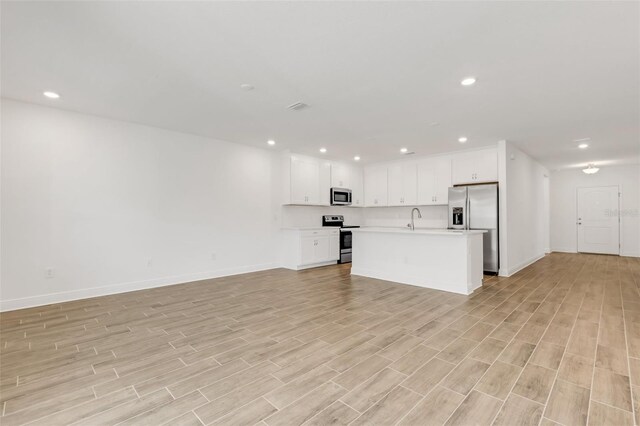 5213 Patano Loop, Palmetto, FL 34221 - unfurnished living room with a sink, light wood-style floors, baseboards, and recessed lighting