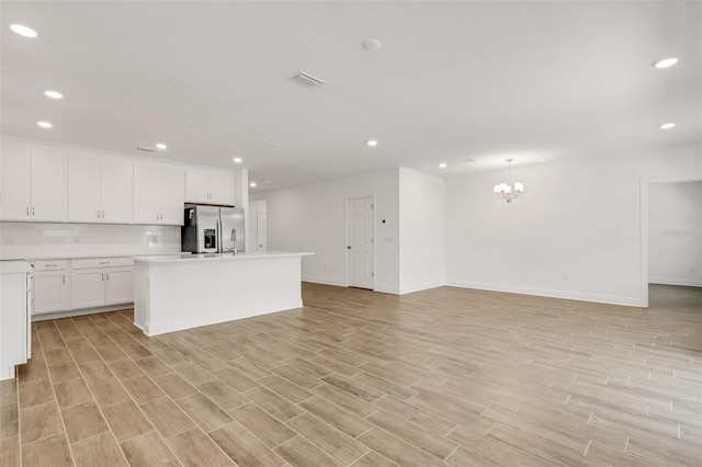 5213 Patano Loop, Palmetto, FL 34221 - kitchen featuring stainless steel fridge, recessed lighting, open floor plan, an island with sink, and light countertops